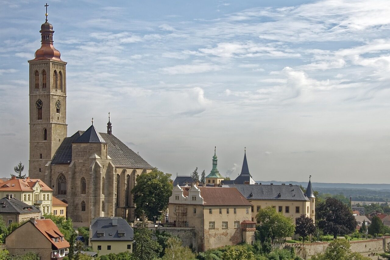 Vysoká věž gotického kostela svatého Jakuba tyčící se nad historickými střechami Kutné Hory
